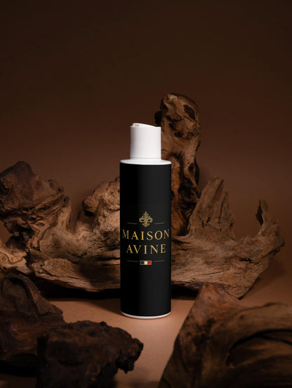 Black cylindrical bottle with white cap labeled 'Maison Avine' on a brown background with wooden elements.